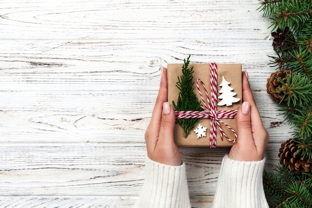 Christmas gift box wrapped in recycled paper, with ribbon bow, with ribbon on rustic vintage table. Holiday concept