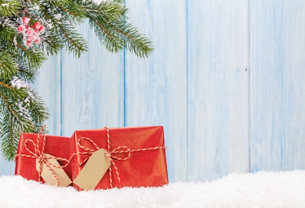 Christmas gift boxes and fir tree branch in snow