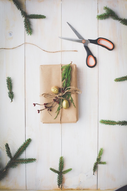 Christmas gift boxes and fir tree branch on wooden table flat lay Shristmas background