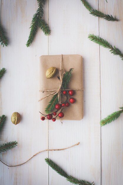 Christmas gift boxes and fir tree branch on wooden table flat lay Shristmas background