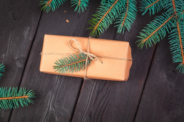 Christmas gift boxes and fir tree branch on wooden table.