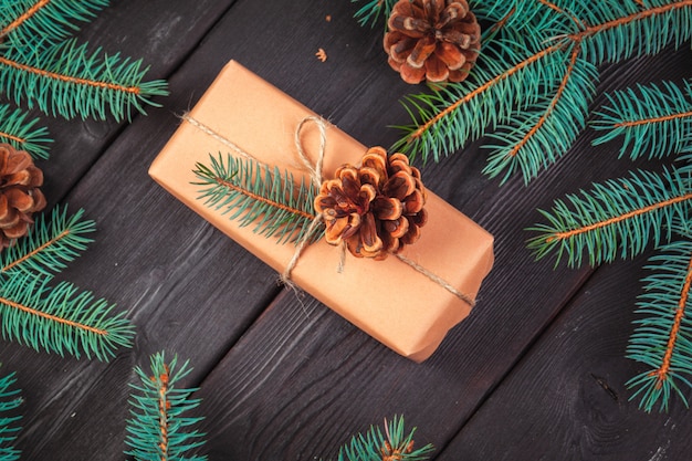 Christmas gift boxes and fir tree branch on wooden table.