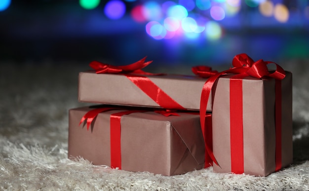 Christmas gift boxes with red ribbon on the floor, close up