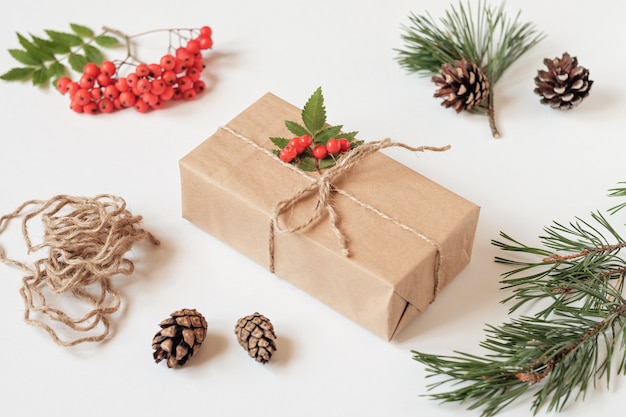 Christmas gift, packed in kraft paper and decorated with a bunch of mountain ash