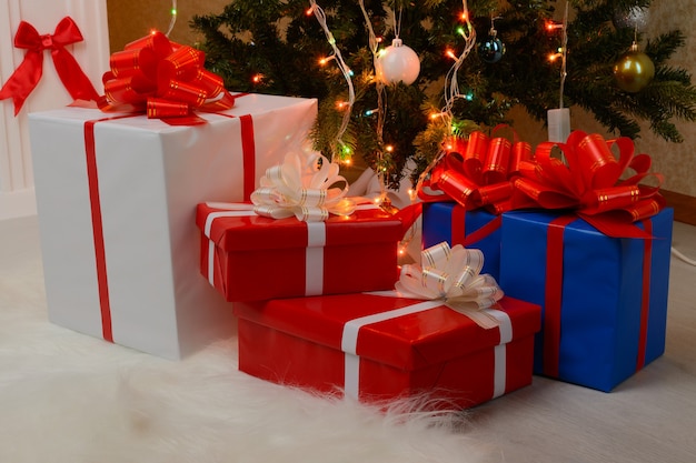 Christmas gifts by the fireplace and fir-tree