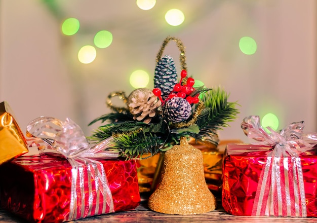 Christmas gifts on the table against the background of blurry lights.