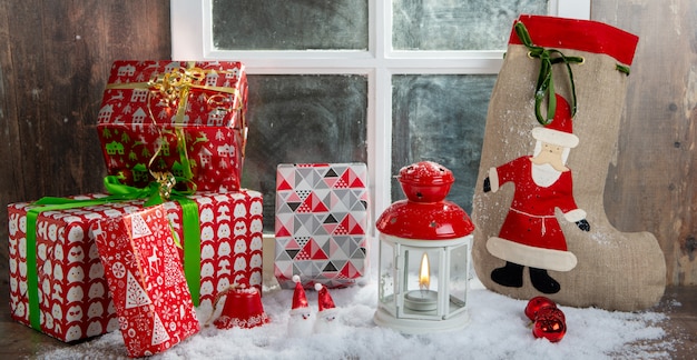 Christmas gifts on the table, near rustic window