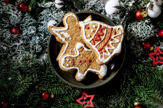 Christmas gingerbread cookies with icing ornate Xmas decorations dark background Top view