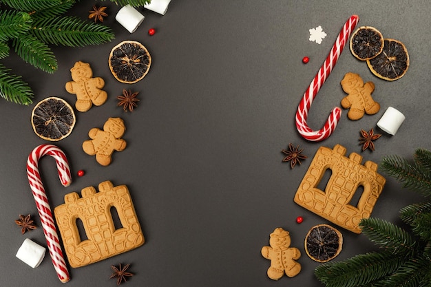 Christmas Gingerbread House cookies biscuit. Traditional festive New Year decor. Black stone concrete background, lifestyle, flat lay, top view