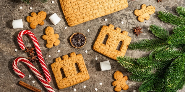 Christmas Gingerbread House and Gingerbread Men. Traditional festive New Year design, cooking process. Modern hard light, dark shadow, flat lay, banner format