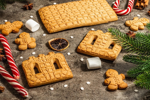 Christmas Gingerbread House and Gingerbread Men. Traditional festive New Year design, cooking process. Modern hard light, dark shadow, flat lay, close up