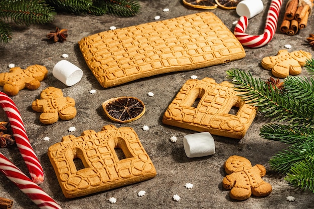 Christmas Gingerbread House and Gingerbread Men. Traditional festive New Year design, cooking process. Modern hard light, dark shadow, flat lay, close up