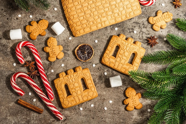 Christmas Gingerbread House and Gingerbread Men. Traditional festive New Year design, cooking process. Modern hard light, dark shadow, flat lay, top view