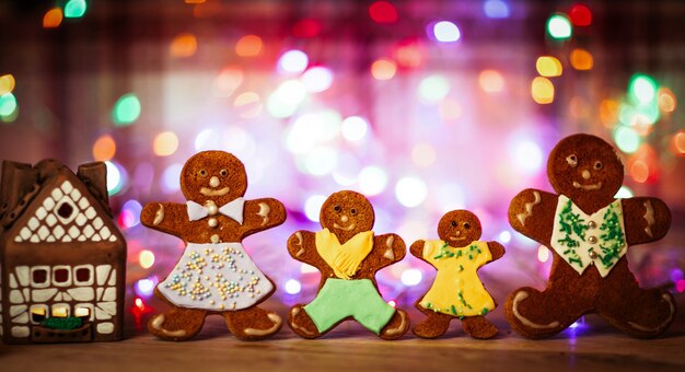 Christmas gingerbread men candles with cinnamon stars Pine twig Christmas ball on a wooden floor