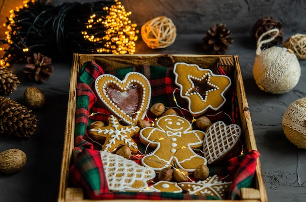 Christmas gingerbread with white icing sugar painted on a dark background.