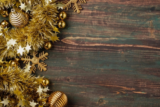 Christmas gold bauble and tinsel decoration ornament on table wood background