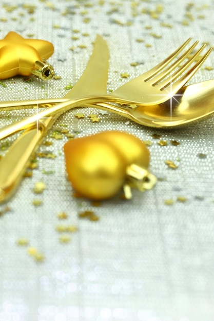 Christmas golden cutlery and ornaments on festive background