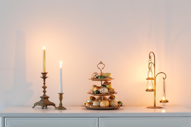 christmas golden decor with burning candles in white interior