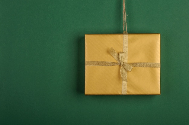 Christmas golden gift on green background