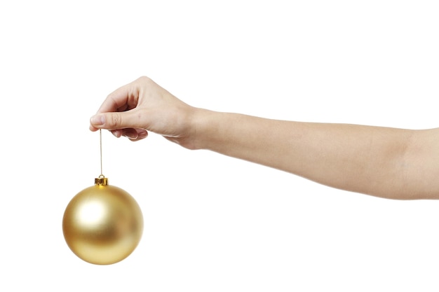 Christmas golden toy ball for the Christmas tree in hand isolated on a white background.