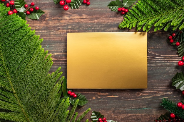 Christmas greeting card mockup with pine leaf and mistletoe on wooden table