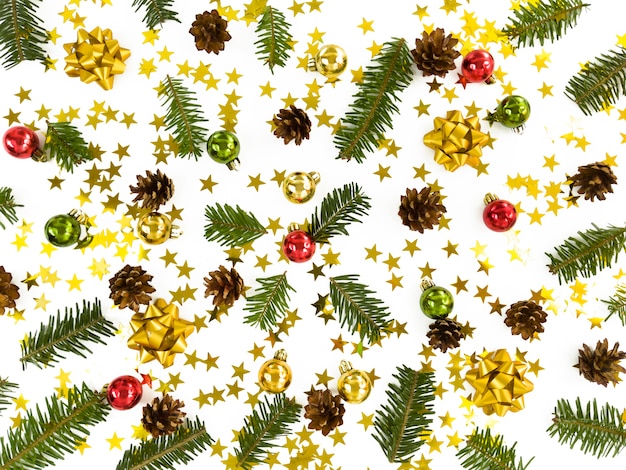 Christmas greeting card. Scattered fir tree branches, baubles, stars, cones and bowes. Simple winter holiday flat lay.