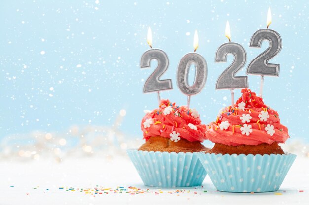 Christmas greeting card with cupcakes and new 2022 year candles