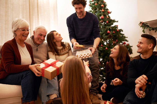 Christmas happy and gift with family in living room for for celebration holiday and festive gratitude Relax smile and present with parents giving box to children at home for content on xmas party