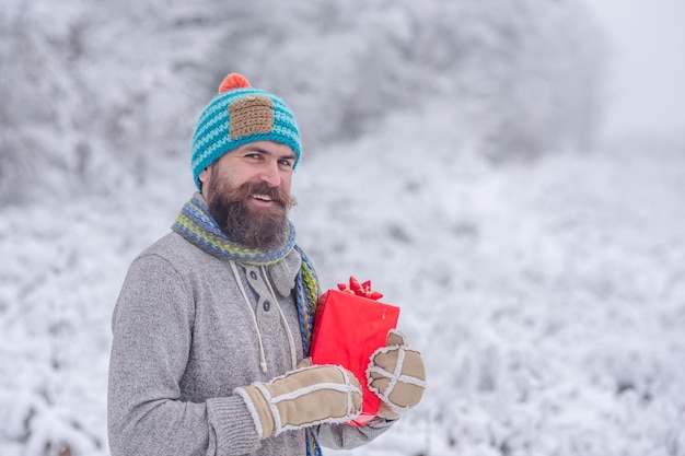 Christmas happy man with beard hold present box.