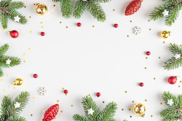 Christmas or Happy New Year composition Frame made of fir tree branches holiday decorations on white background