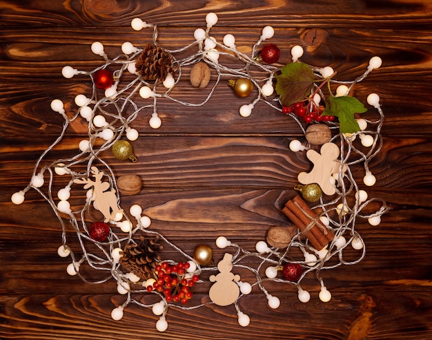 Christmas and Happy New Year on holiday background with natural cones, nuts, wooden toys. Xmas card, bokeh, sparking, glowing. Winter holidays concept. Flat lay, top view