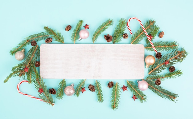 Christmas holiday background, frame with fir branches, baubles, candy cane and cones, winter season