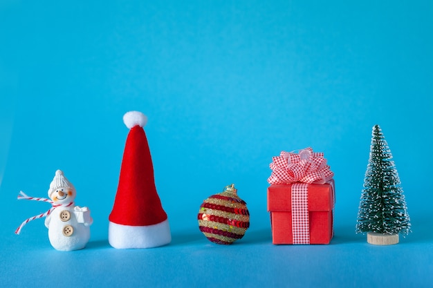 Christmas holiday celebration concept with Christmas tree and ball, Santa Hat, gift box, snowman