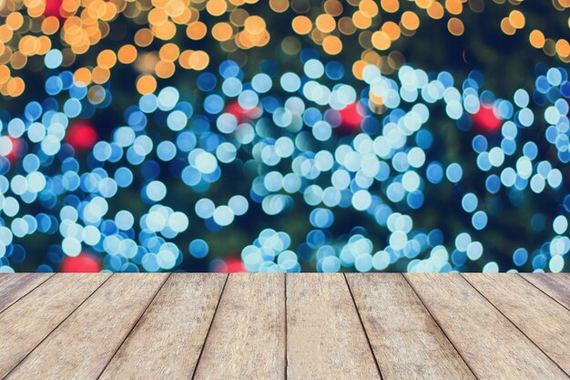 Christmas holiday with empty wooden table top over festive bokeh light decorate on Christmas tree.