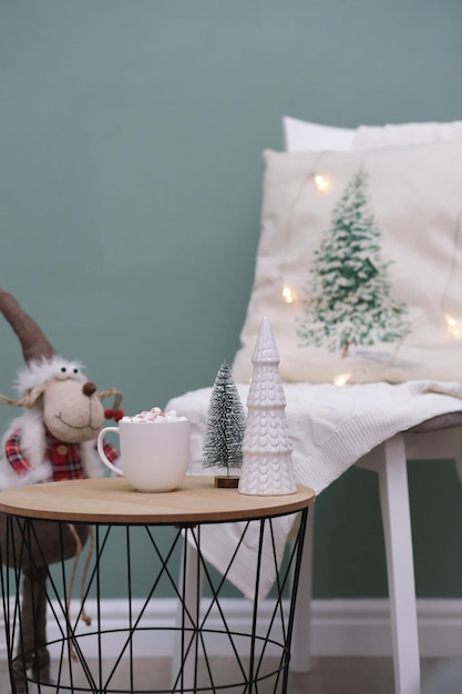 Christmas home decorations cup of cocao with marshmellow ceramic christmas tree on coffee table