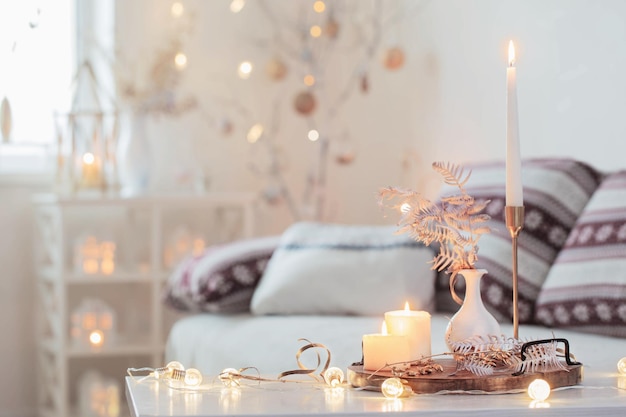 Christmas home decorations with candles in white interior