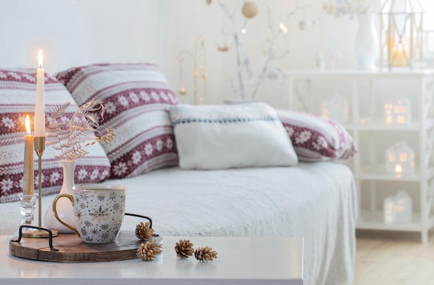 Christmas home decorations with candles in white interior