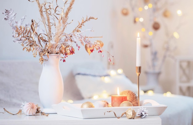 Christmas home decorations with candles in white interior