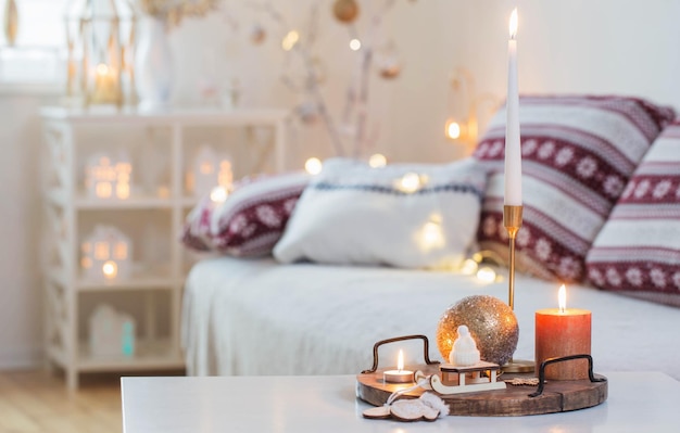 Christmas home decorations with candles in white interior