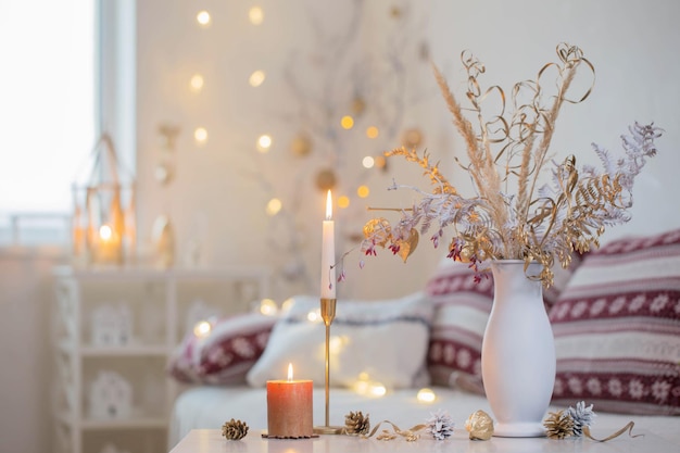 Christmas home decorations with candles in white interior