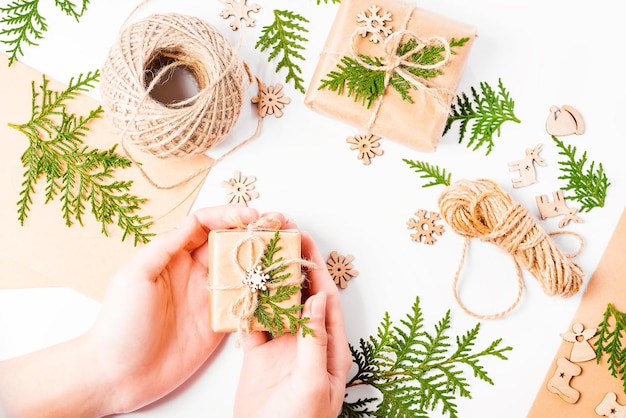 Christmas home decorThe girl's hands make a composition of New Year's giftsNew Year's gifts