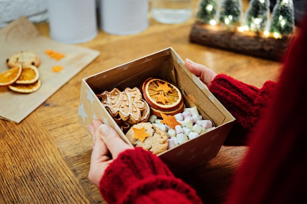 Christmas homemade sweet hampers in female hands woman hsnds holding christmas sweet gift box