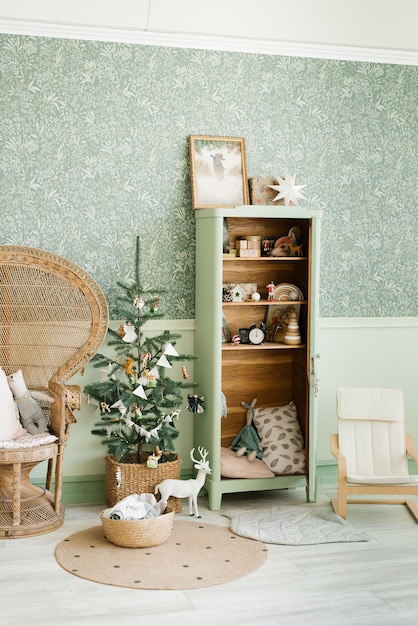 Christmas interior of the children's room in mint colors A Christmas tree in a wicker basket with toys a cabinet with books and toys