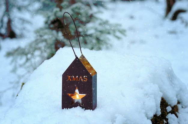 Christmas lantern with fir twigs on the snow