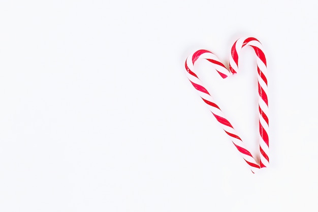 Christmas layout. Striped red-white cane candies on a white background. New Year 2019, christmas