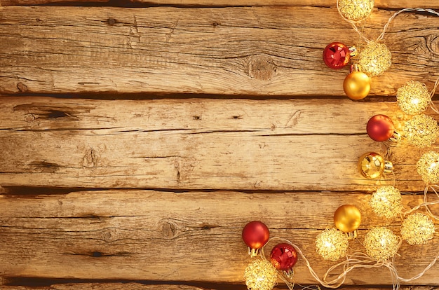 Photo christmas lights and balls on a wooden background with copy space