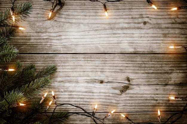 Christmas lights bulb and  fir branch on rustic wood table