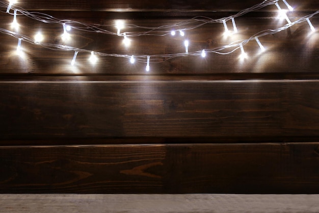 Christmas lights glowing on wooden background