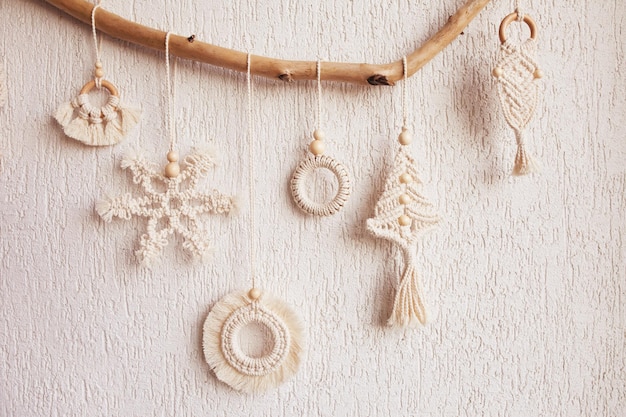 Christmas macrame decor Christmas snowflake and decorative elements on wooden stick Natural materials cotton thread wood beads Eco decorations ornaments hand made decor Copy space