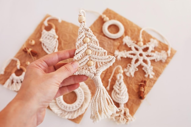 Christmas macrame decor Christmas toy on wooden board Natural materials cotton thread wood beads and stick Eco decorations ornaments hand made decor Winter and New Year holidays